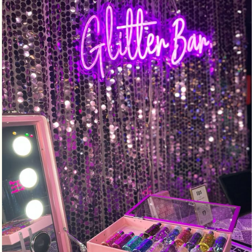 Invitados aplicándose glitter y neones en el Brava Glow Up de Brava Eventos en una boda en coruña
